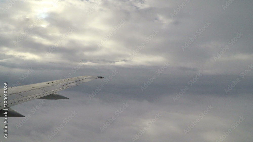 Sunshine rays pouring from between clouds as the airplane descends. Sunshine rays pouring from between clouds as the airplane descends.