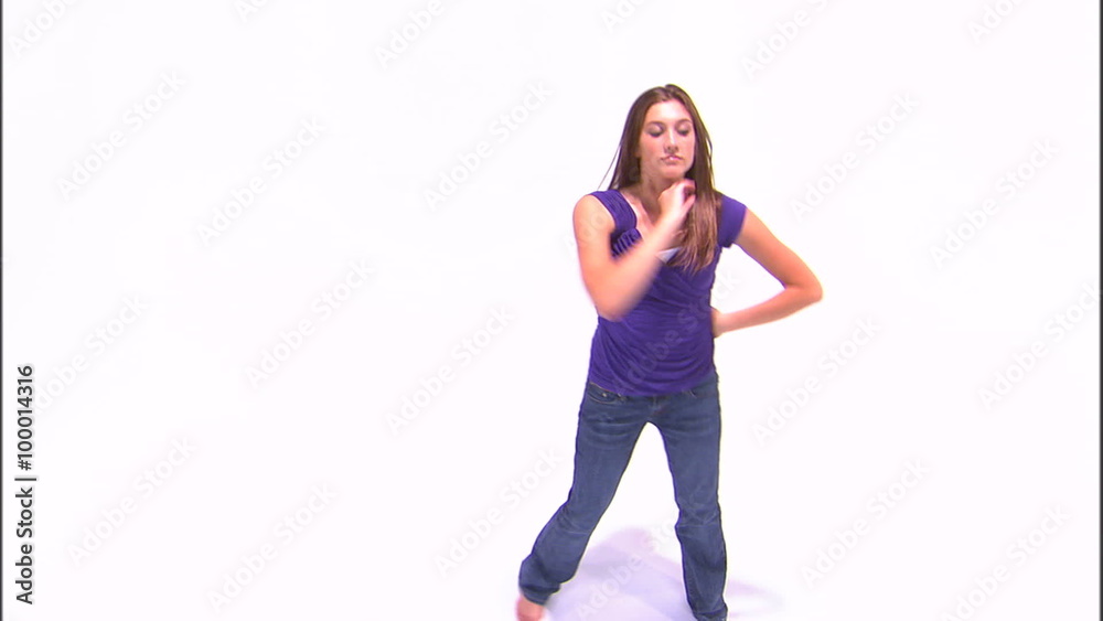 Girl dancing on a white background in a purple shirt and jeans. Girl dancing on a white background in a purple shirt and jeans.