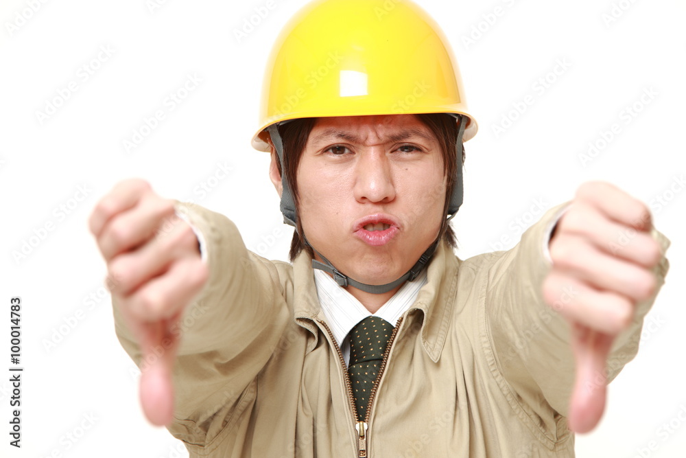 young Japanese construction worker with thumbs down gesture