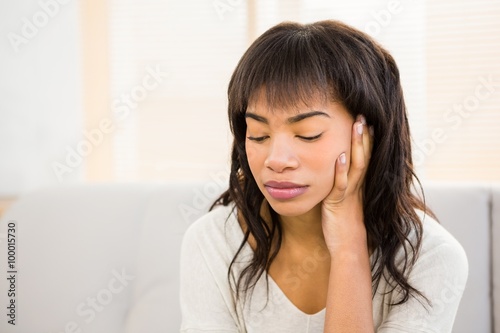 Stressed woman holding her head on couch
