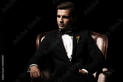 Portrait of man who sitting on chair, godfather-like character. photo