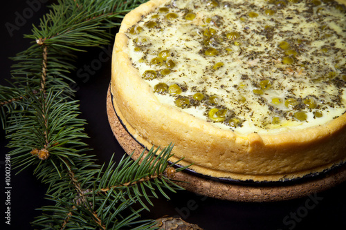 Pie with filling with Christmas tree branches on a black backgro photo