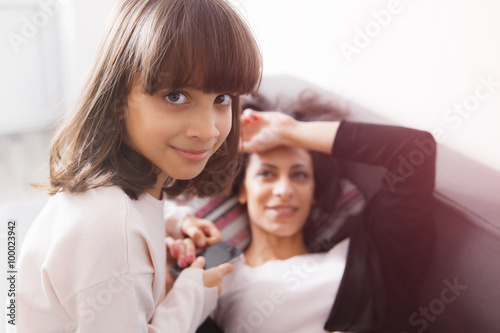 Young mother and daughter sitting on the sofa