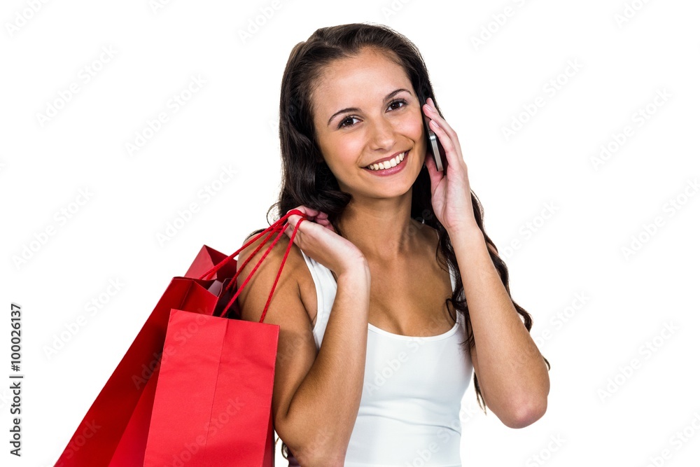Smiling woman holding shopping bags while using smartphone Smiling woman holding shopping bags while using smartphone