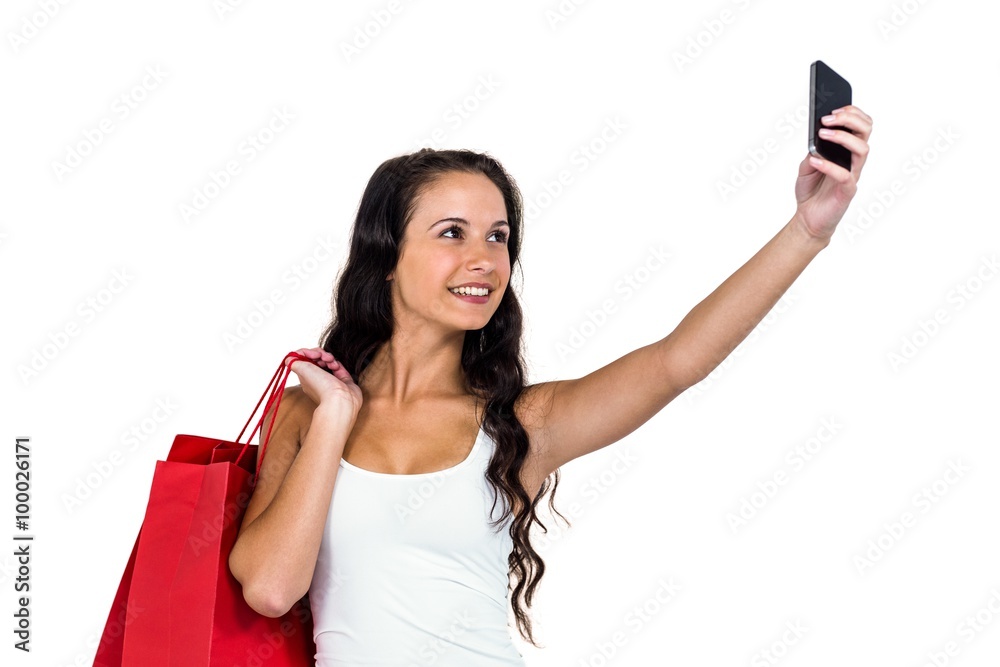 Smiling woman holding shopping bags taking selfie Smiling woman holding shopping bags taking selfie