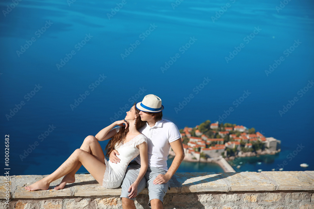 Romantic young couple in love over sea shore above Sveti Stefan