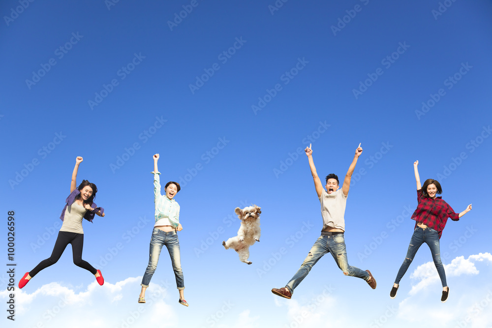 happy young group jumping together with dog happy young group jumping together with dog