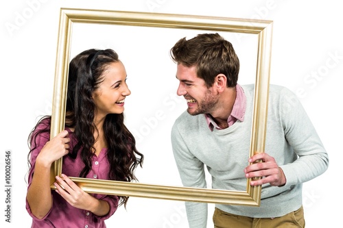 Stylish couple holding picture frame