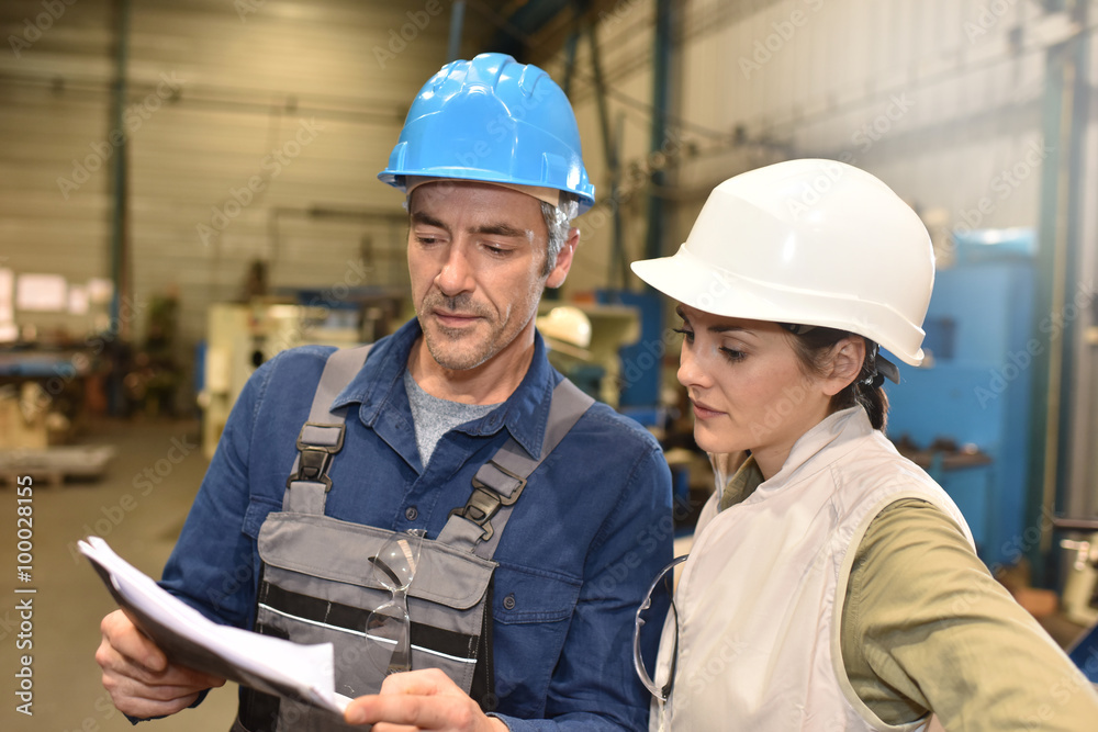 Metal worker showing machine room to apprentice Metal worker showing machine room to apprentice