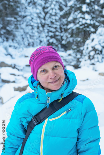 Portrait of a smiling hiker woman in a winter forest