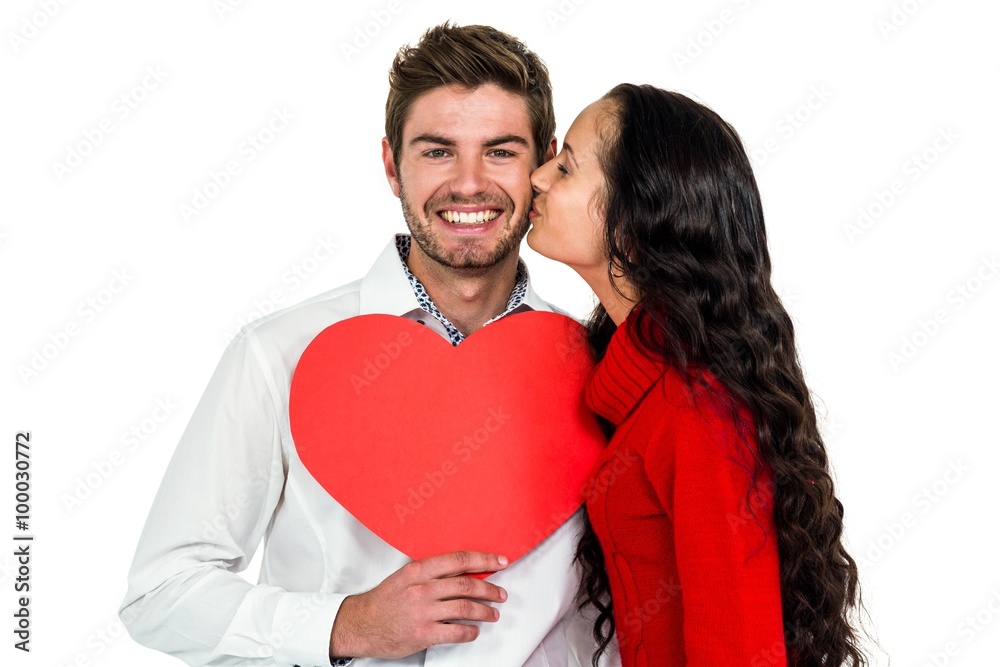 Man holding paper heart and being kissed by girlfriend