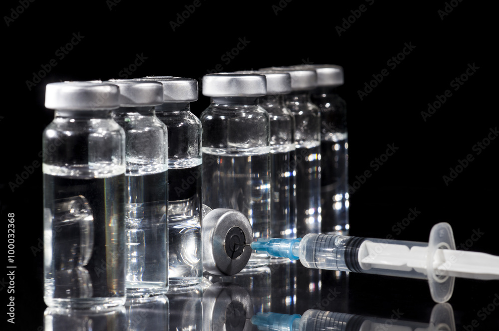 Glass Medicine Vials and Syringe on black background Glass Medicine Vials and Syringe on black background