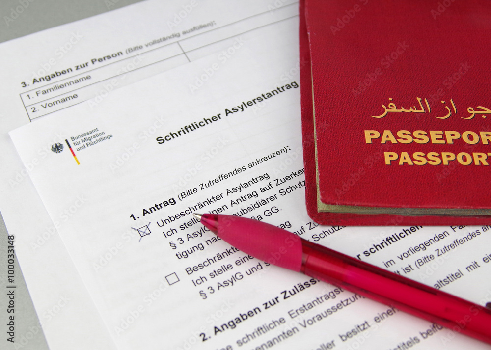 Schriftlicher Asylantrag mit Pass und Kugelschreiber StockFoto Adobe