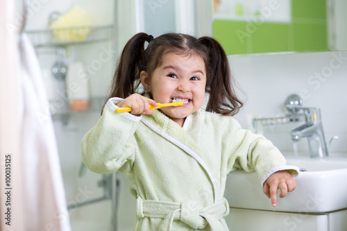 Child girl brushing teeth i...