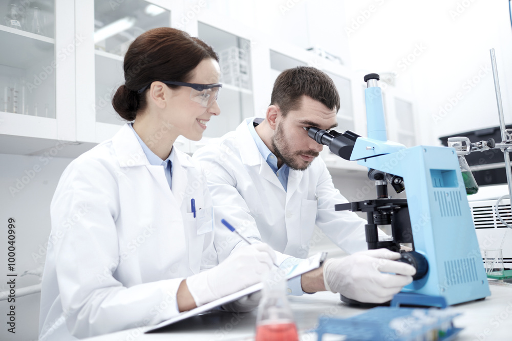 scientists with clipboard and microscope in lab scientists with clipboard and microscope in lab