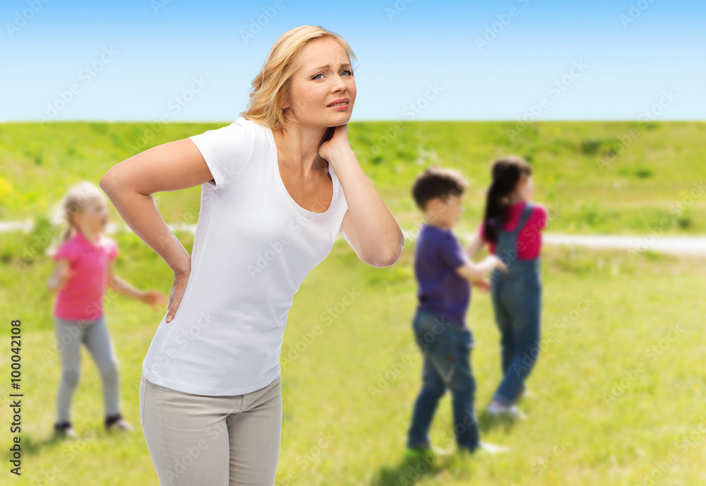Fototapeta premium woman suffering from backache over group of kids