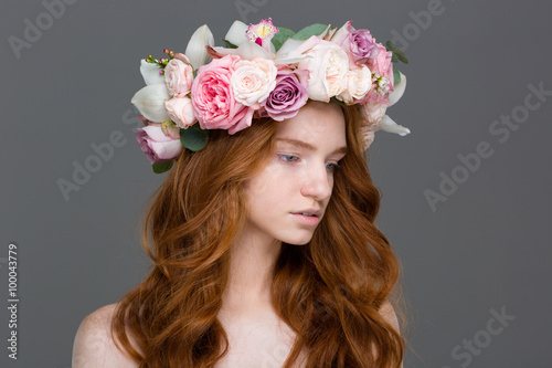 Beautiful tender woman with long hair in wreath of roses