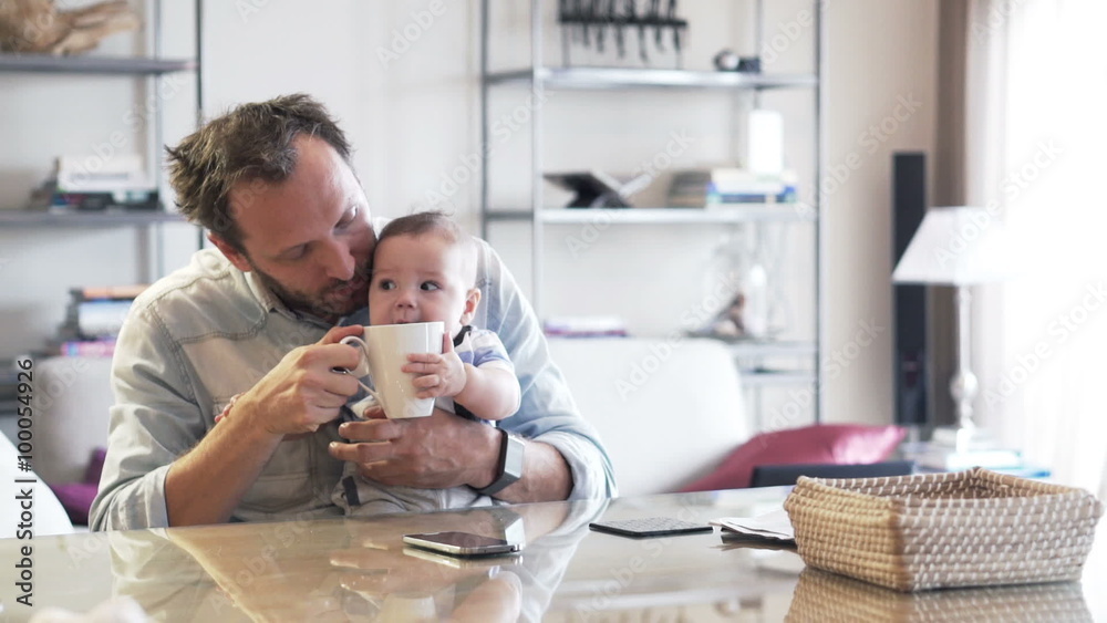 Young father drinking and playing with little child at home
Young father drinking and playing with little child at home