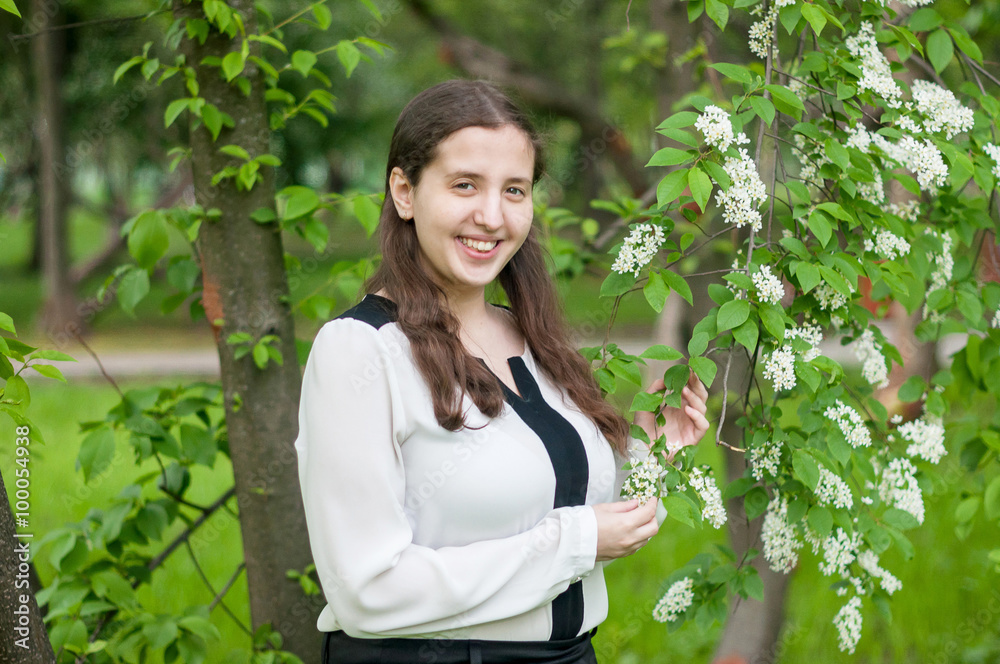Girl schoolgirl walks in the lush spring garden after school Girl schoolgirl walks in the lush spring garden after school