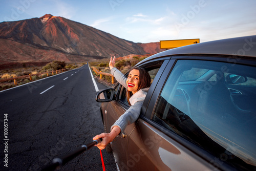 Woman in car with volcano on background