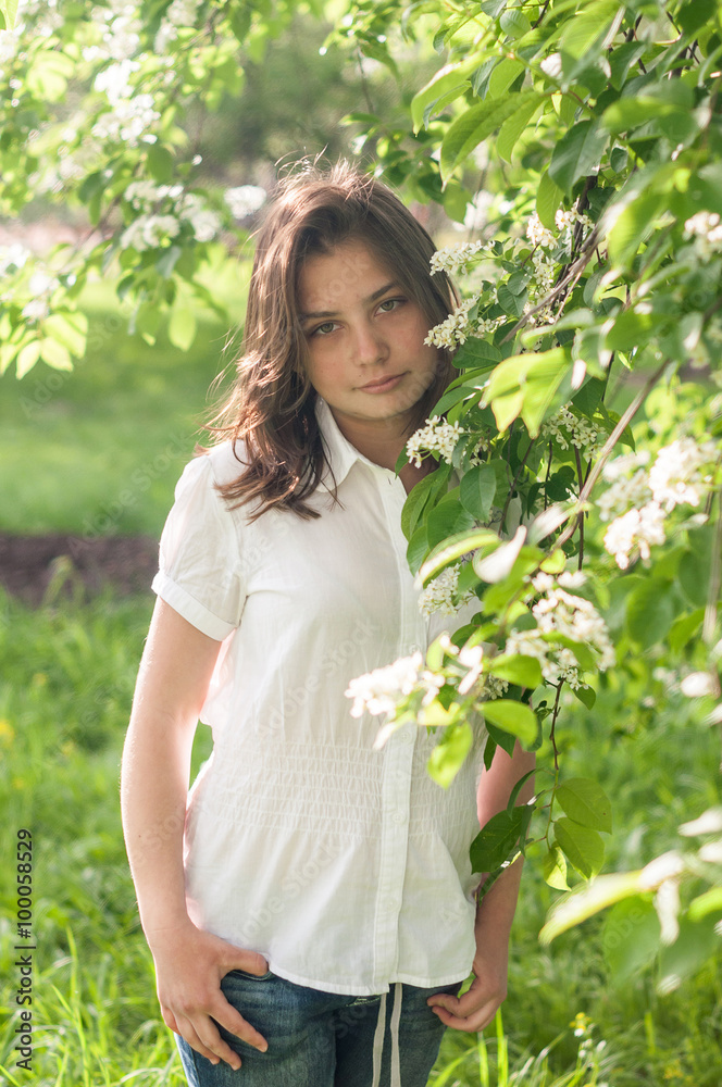 young girl posing in a park in spring blooming garden young girl posing in a park in spring blooming garden