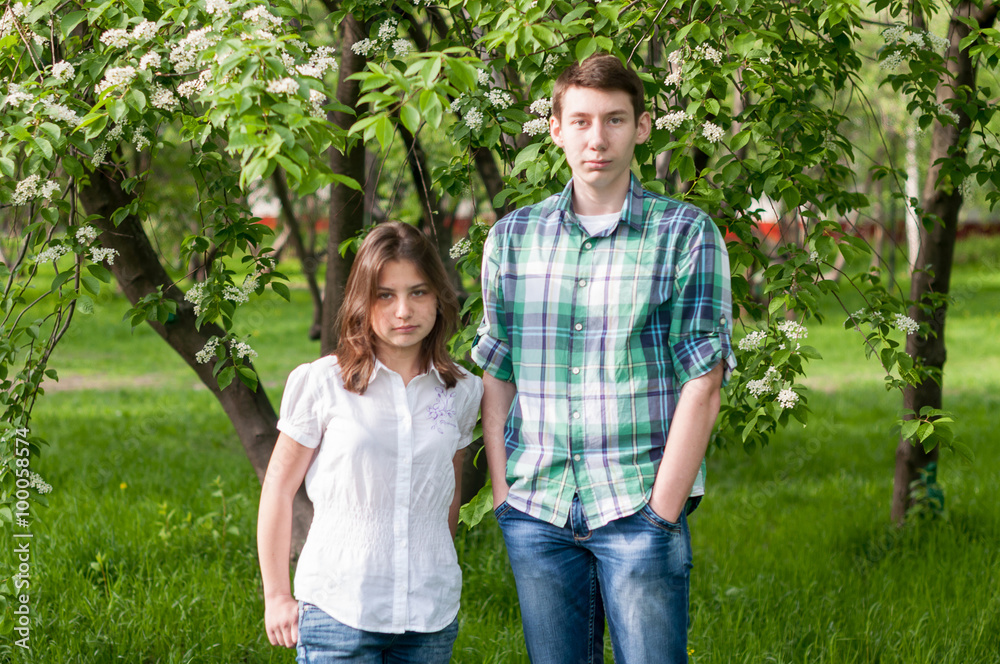Fototapeta premium young couple walking in a flowery park on a summer day