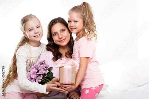 Happy family. Mother and daughters with gift box and flowers. Mother's day. 8 march