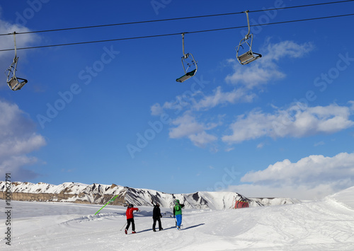 Three skiers on slope at sun nice day photo