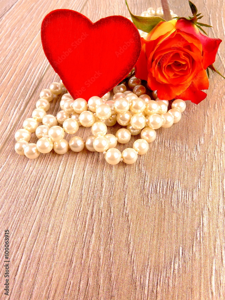 Rote Rose mit Herz und Perlenkette
