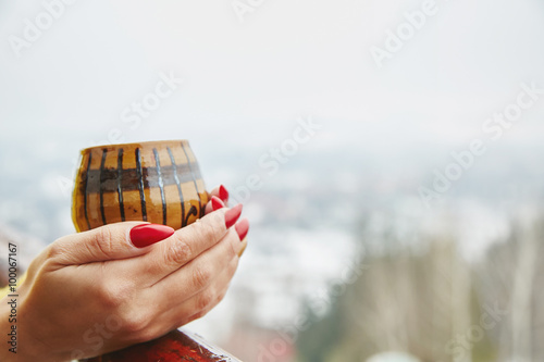 Hands holding a traditional cup of coffee