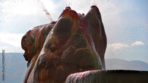 Close-up shot of water shooting out of the top of the colorful Fly Geyser in Nevada.