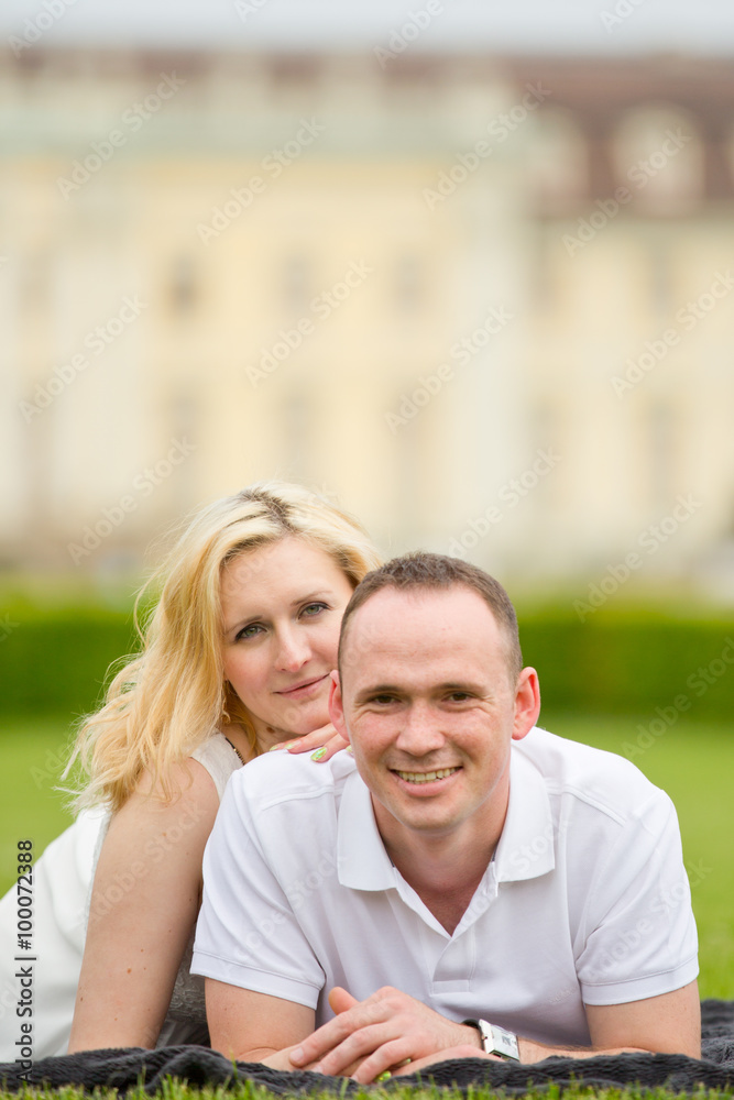 Obraz premium Young, happy and smiling couple lies on a grass