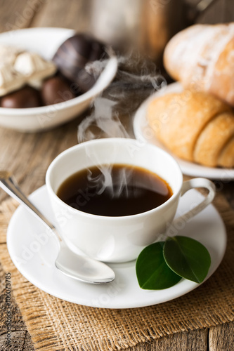 Hot coffee and pastries on a wooden background