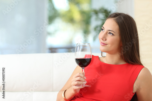 Pensive relaxed woman with a cup of wine