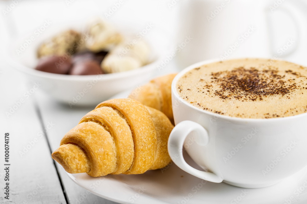 Hot cappuccino and pastries on white wooden boards Hot cappuccino and pastries on white wooden boards