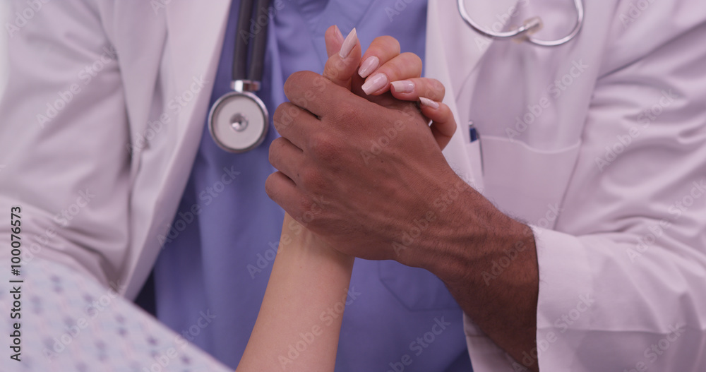 Closeup of African doctor holding patient's hand Closeup of African doctor holding patient's hand