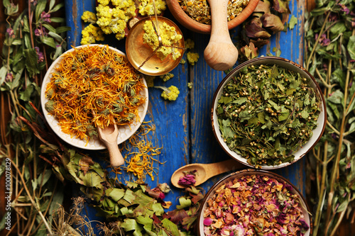 Fototapeta Naklejka Na Ścianę i Meble -  Assortment of dry medicinal herbs in bowls on wooden background top view