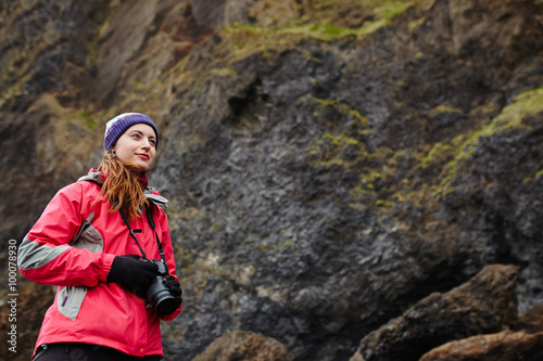  Young traveler woman holding camera in Iceland. Beautiful cauca