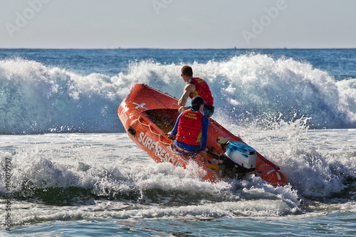 Surf lifesavers guide their dinghy out from the beach into heavy surf. 