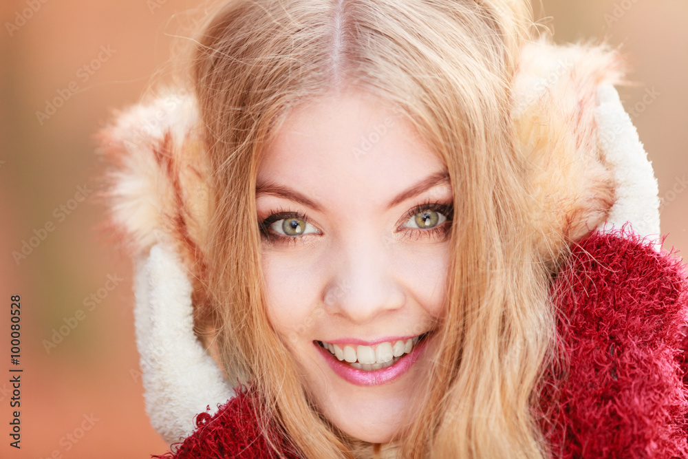 Portrait of pretty smiling woman in earmuffs. Portrait of pretty smiling woman in earmuffs.