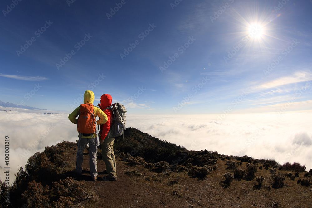 two successful backpacker enjoy the beautiful landscape at sunrise mountain peak