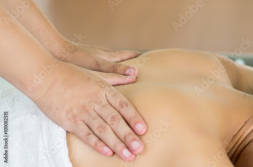 Closeup womans upper back with hands working on giving massage, spa treatment concept