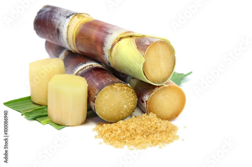 Sugarcane with leaves , pieces of sugarcane and brown sugar on white background.