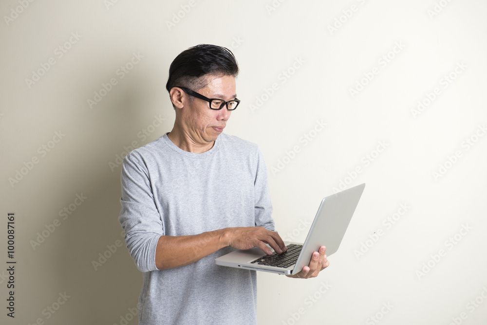asian casual senior with laptop
