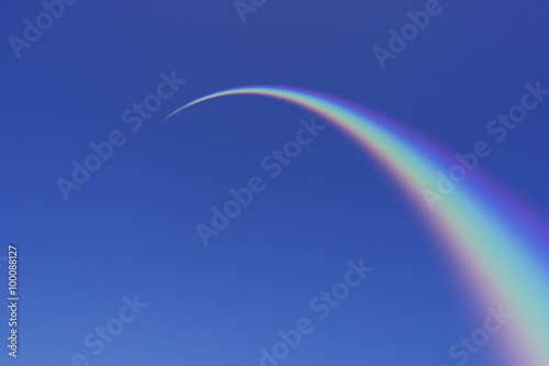 Rainbow Arcing Through Blue Sky