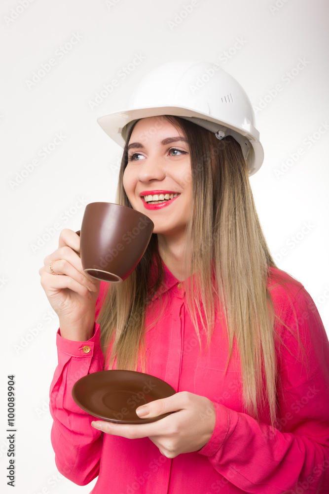 beautiful woman civil engineer holding blueprints. young female architect drinking coffee from a brown cup