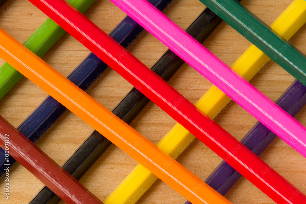 Intersecting color pencils on the wooden surface Intersecting color pencils on the wooden surface
