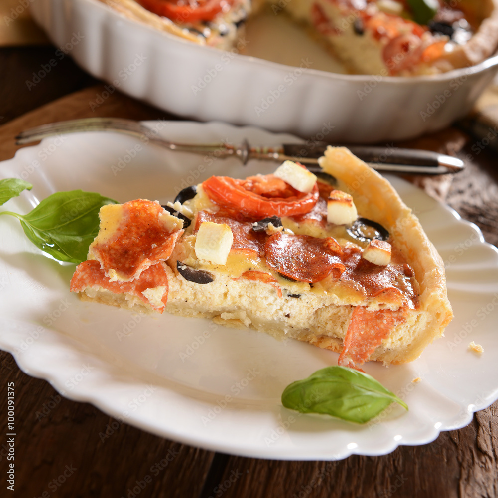 Tart (Quiche) with tomatoes, basil, salami, black olives and che Tart (Quiche) with tomatoes, basil, salami, black olives and che
