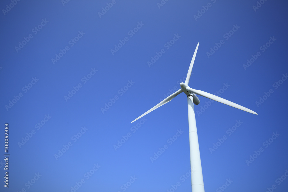 Power generating wind turbine on blue sky with sun. Power generating wind turbine on blue sky with sun.