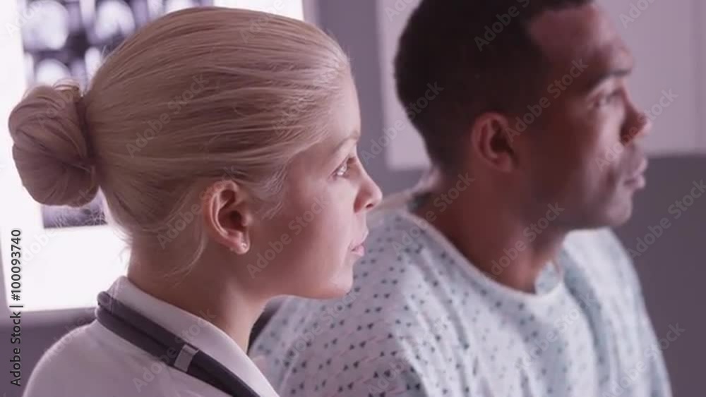 Woman doctor and black patient looking at xrays